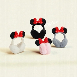 Puede incluir: Cuatro pares de orejeras en negro, blanco, rosa y gris. Cada par presenta orejas de ratón negras y un lazo rojo con lunares blancos. Las orejeras están hechas con un material suave y afelpado.