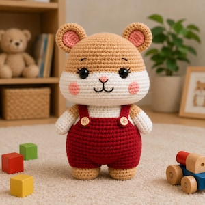 May include: A handmade crochet hamster toy with a tan head and ears, white face and arms, and red overalls. The toy has black eyes, pink cheeks, and small brown buttons. It is a cute, soft toy.