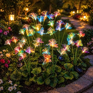 Könnte beinhalten: Ein Gartenbeet mit solarbetriebenen Glasfaser-Blumenlichtern. Die bunten Lichter sind kreisförmig angeordnet, wobei jede Blume ein Farbspektrum zeigt. Die Szene wird durch sanfte Gartenlichter im Hintergrund beleuchtet.