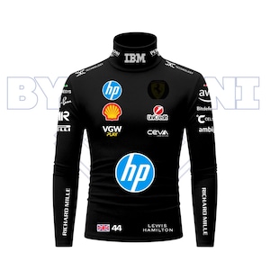 Puede incluir: Camiseta negra de manga larga con cuello alto y logotipos de patrocinadores, incluyendo HP, Shell y Ferrari. Presenta el texto "LEWIS HAMILTON" y el número "44" con una bandera de la Union Jack. La camiseta también tiene "RICHARD MILLE" impreso en las mangas.