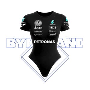 May include: A white ceramic mug with a black handle and the text "But First, Coffee" in a bold, black font. The mug is set against a blurred background, suggesting a cozy setting.