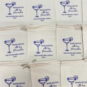 Puede incluir: Bolsas de cord&oacute;n de color crema con un dise&ntilde;o de vaso de margarita azul y texto. El texto dice "MARGARITAS with her Mamasitas" y "THE FUTURE MRS. GARCIA 2025". Las bolsas son probablemente para una despedida de soltera.