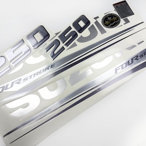 May include: A set of silver and black decals with the number "250" and the words "FOUR STROKE" printed on them. The decals are on a white background and appear to be for a vehicle or engine.
