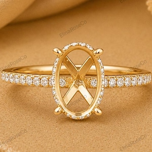 May include: A gold ring featuring an oval-shaped center setting with an X-shaped bridge. The band is adorned with a row of small, clear pavé-set stones that extend along the sides, creating a delicate and refined appearance for this jewelry piece.