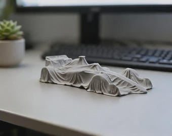 Maqueta de coche de carreras impresa en 3D bajo cubierta: decoración única para el automovilismo.