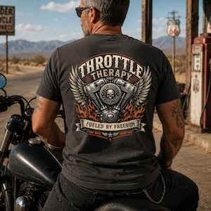 May include: A charcoal gray t-shirt featuring a large back graphic of a motorcycle engine with wings, flames, and a skull. The text reads THROTTLE THERAPY, FUELED BY FREEDOM, TWO WHEELS FIX EVERYTHING, and RIDE MORE WORRY LESS in a vintage style.