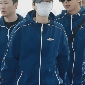 Peut inclure: Plusieurs personnes portant des vestes à capuche bleu marine avec des bordures blanches et l'inscription "KEEP SWIMMING". Une personne porte une casquette grise et un masque, une autre une casquette bleue et des lunettes de soleil.