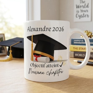 Peut inclure: Un mug en céramique blanc orné d'une toque de diplômé noire avec un pompon doré et un diplôme enroulé avec un ruban rouge. Le texte indique Alexandre 2026, Objectif atteint et Nouveau chapitre en polices d'écriture et d'imprimerie noires.