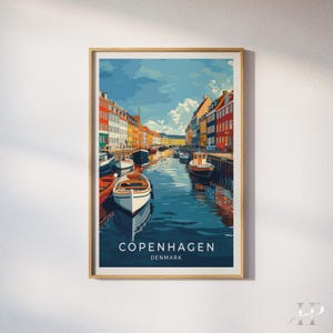 May include: A framed vertical art print depicting the Nyhavn canal in Copenhagen, Denmark. The scene features colorful buildings lining the water, several small boats moored in the canal, and a blue sky with clouds. The text COPENHAGEN DENMARK is printed.