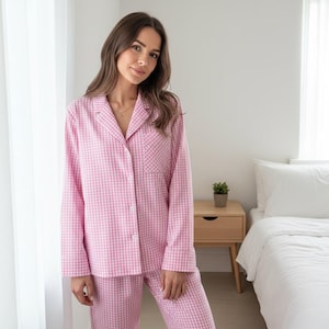 Könnte beinhalten: Rosa-weiß kariertes Pyjama-Set. Das langärmlige Hemd mit Knopfleiste hat eine Brusttasche und die Hose hat eine lockere Passform. Der Pyjama ist aus einem weichen, bequemen Stoff gefertigt.