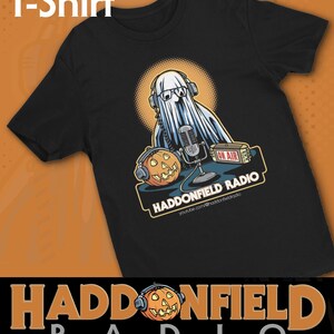 Könnte beinhalten: Schwarzes T-Shirt mit einem Cartoon-Geist mit Kopfhörern und Brille, der aus einem Studio mit einem Mikrofon und einem Kürbis sendet. Das Shirt trägt den Text "HADDONFIELD RADIO" und "ON AIR". Auf der Oberseite des Shirts steht "T-Shirt".