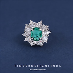 Może przedstawiać: Biały ceramiczny kubek z czarnym uchwytem i napisem "But First, Coffee" w stylu odręcznym. Kubek stoi na białej powierzchni. Kubek ma około 10 cm wysokości.