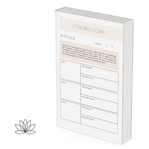 May include: A white notebook with the words "COACHING GOALS" at the top. The notebook has a light beige header and a section for writing goals, with prompts for "Why it's important" and "Measurable Outcome."