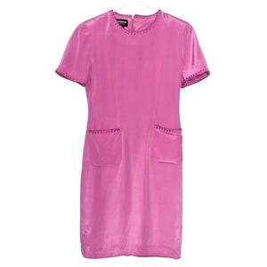May include: A bright pink dress with short sleeves and two front pockets. The dress has a round neckline and the edges of the sleeves and pockets are trimmed with a darker pink decorative stitching. The dress is hanging on a white hanger.