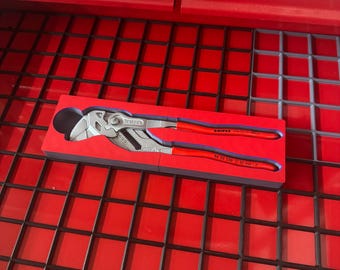 May include: A Knipex pliers wrench with red handles and a silver head, resting in a red foam insert. The tool is displayed inside a red toolbox drawer.