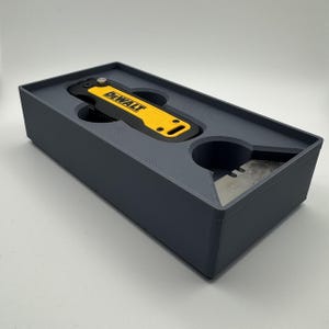 Peut inclure: Une tasse en céramique blanche avec une anse noire et le texte "But First, Coffee" en gras noir. La tasse contient un liquide foncé, probablement du café, posée sur une surface claire.