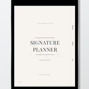 Puede incluir: Una tableta digital negra muestra una página color crema con las palabras "SIGNATURE PLANNER" en una fuente serif. También se ve el texto "Undated Edition" y "Structure, with softness".