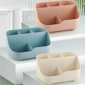 Op de afbeelding: Drie pastelkleurige bureau-organizers. Elke organizer heeft meerdere compartimenten voor opslag. De kleuren zijn lichtroze, lichtblauw en crème. De organizers zijn gemaakt van plastic en hebben een afgeronde vorm.