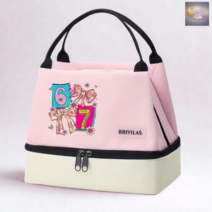 Peut inclure: Sac à déjeuner isotherme rose avec des poignées noires et un fond crème. Le sac présente les chiffres 6 et 7 avec des graphiques de nœuds et de fleurs. La marque "BRIVILAS" est imprimée sur le devant.