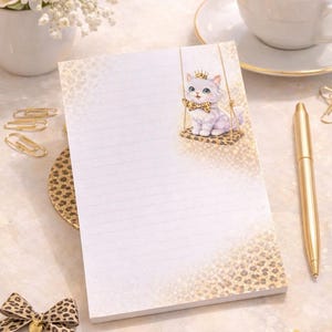 Könnte beinhalten: Liniertes Notizbuch mit einem dekorativen Leopardenmuster-Rand und einer charmanten Illustration eines Kätzchens mit Krone und Fliege. Ein goldener Stift, Büroklammern und eine Tasse Kaffee sind ebenfalls zu sehen.