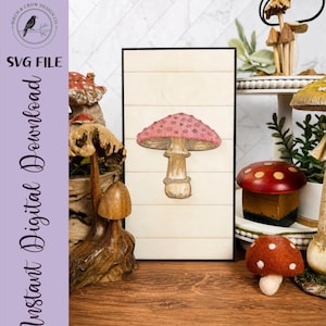 May include: A rectangular sign with a horizontal shiplap pattern features a central illustration of a pink-capped mushroom with white spots. The text "BIRCH & CROW DESIGN CO" and "SVG FILE Instant Digital Download" appears on the left side.