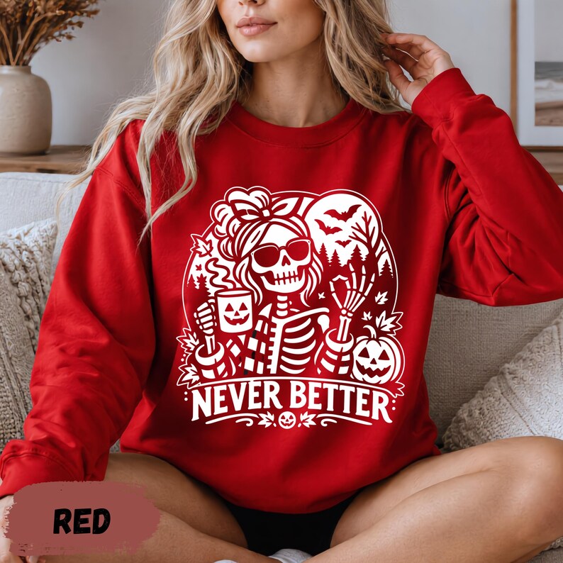 Könnte beinhalten: Ein rotes Langarm-Sweatshirt mit einem weißen Grafikdruck eines Skeletts, das eine Sonnenbrille und eine Haarschleife trägt und eine Kürbistasse hält. Das Design zeigt Fledermäuse, Bäume und einen Kürbis mit dem Schriftzug NEVER BETTER.