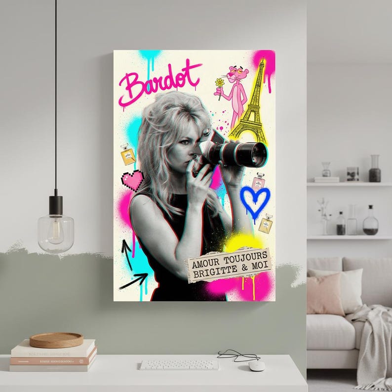 Może przedstawiać: Czarno-biały nadruk w stylu pop-art z Brigitte Bardot trzymającą aparat fotograficzny. Nadruk zawiera akcenty w stylu graffiti w kolorze r&oacute;żowym, niebieskim i ż&oacute;łtym, z Wieżą Eiffla i R&oacute;żową Panterą. Tekst zawiera "Bardot" i "Amour Toujours Brigitte & Moi."