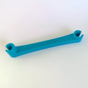 May include: A turquoise plastic tool with the text "PROTO POINT" embossed on the top. The tool has a ridged handle and curved ends with a circular opening. The tool is designed for a specific purpose.