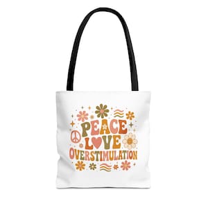 Könnte beinhalten: Weiße Tragetasche mit schwarzen Griffen. Die Tasche zeigt die Worte "PEACE LOVE OVERSTIMULATION" in einem Retro-Schriftzug mit Blumen- und Friedenszeichen-Grafiken in Orange, Braun und Grün.