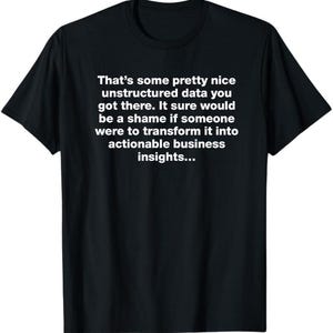 以下が含まれることがあります： 白いテキストがプリントされた黒い半袖Tシャツ。テキストの内容は「That's some pretty nice unstructured data you got there. It sure would be a shame if someone were to transform it into actionable business insights...」です。