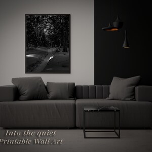 Peut inclure: Impression en noir et blanc d'un chemin enneigé dans une forêt, encadrée et accrochée au-dessus d'un canapé gris. Le texte "Into the quiet Printable Wall Art" est visible en bas de l'image.
