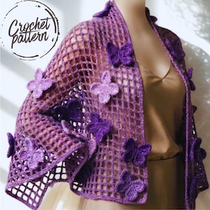 Peut inclure: Un châle en crochet violet orné de papillons. Le châle ajouré présente de multiples applications de papillons en 3D de différentes nuances de violet. Le texte "Crochet Pattern" est dans un cercle en haut à gauche.