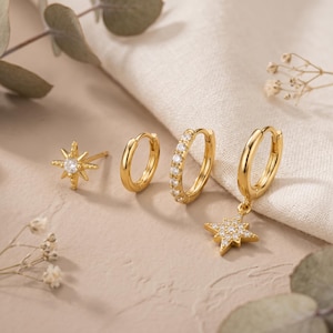 Könnte beinhalten: Ein Set aus vier goldfarbenen Ohrringen, bestehend aus einem sternförmigen Stecker mit einem zentralen klaren Stein, einem schlichten kleinen Creolen-Ohrring, einem mit klaren Steinen besetzten kleinen Creolen-Ohrring und einem Creolen-Ohrring mit Sternanhänger.