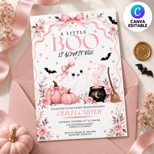 May include: A baby shower invitation card featuring a white background with pink floral borders, a pink bow, bats, two pink pumpkins, a ghost with a pink bow, a black cauldron with pink smoke, and a broom. Text reads A LITTLE BOO IS ALMOST DUE.
