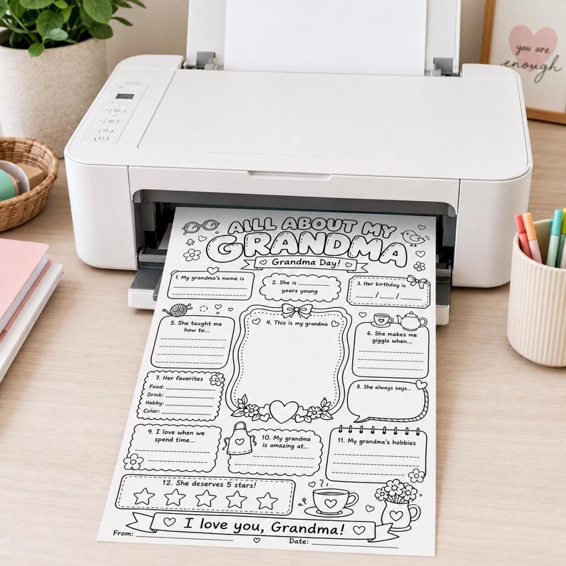 May include: A white printer outputting a black and white printable activity sheet titled All About My Grandma. The sheet features eleven fill-in-the-blank sections, a large central frame for a drawing, and a five-star rating area for Grandma.