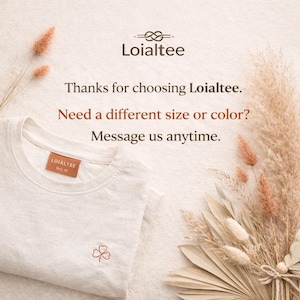 K&ouml;nnte beinhalten: Ein wei&szlig;es T-Shirt mit Rundhalsausschnitt, einem kleinen gestickten Kleeblatt und einem braunen Etikett mit der Aufschrift "LOIALTEE Gr&ouml;&szlig;e M". Das Bild enth&auml;lt den Text "Vielen Dank, dass Sie sich f&uuml;r Loialtee entschieden haben. Ben&ouml;tigen Sie eine andere Gr&ouml;&szlig;e oder Farbe? Schreiben Sie uns jederzeit."