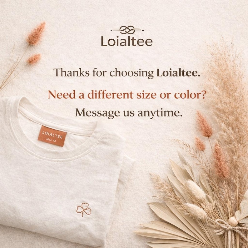 K&ouml;nnte beinhalten: Ein wei&szlig;es T-Shirt mit Rundhalsausschnitt, einem kleinen gestickten Kleeblatt und einem braunen Etikett mit der Aufschrift "LOIALTEE Gr&ouml;&szlig;e M". Das Bild enth&auml;lt den Text "Vielen Dank, dass Sie sich f&uuml;r Loialtee entschieden haben. Ben&ouml;tigen Sie eine andere Gr&ouml;&szlig;e oder Farbe? Schreiben Sie uns jederzeit."