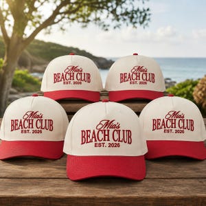 Può includere: Cinque cappellini da baseball con corona color crema e visiera rossa. Ogni cappellino presenta la scritta ricamata in rosso Mia's BEACH CLUB EST. 2026. I cappellini sono disposti in gruppo, mostrando i pannelli frontali e il design.