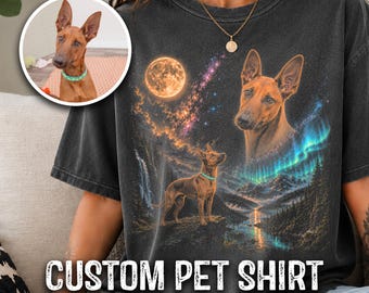 May include: A charcoal grey t-shirt featuring a graphic print of a brown dog with pointed ears. The design includes a full moon, a starry sky, a waterfall, a mountain landscape, and an aurora borealis. The text CUSTOM PET SHIRT is printed below.