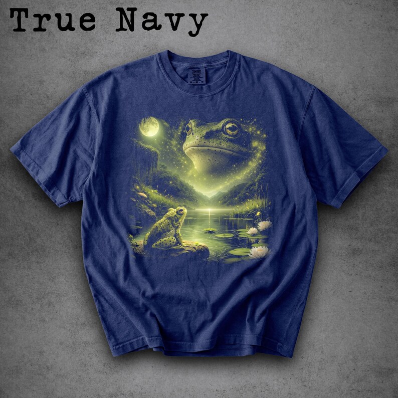 May include: True Navy t-shirt featuring a detailed illustration of two frogs in a serene, moonlit pond setting. The design includes a large frog's face and a smaller frog on a rock, with the text "True Navy" at the top.