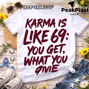 May include: A white short-sleeved t-shirt featuring dark red text that reads: KARMA IS LIKE 69: YOU GET, WHAT YOU GIVIE. The lettering has a distressed, brush-stroke appearance, and the shirt is made of a plain, lightweight fabric with a crew neckline.