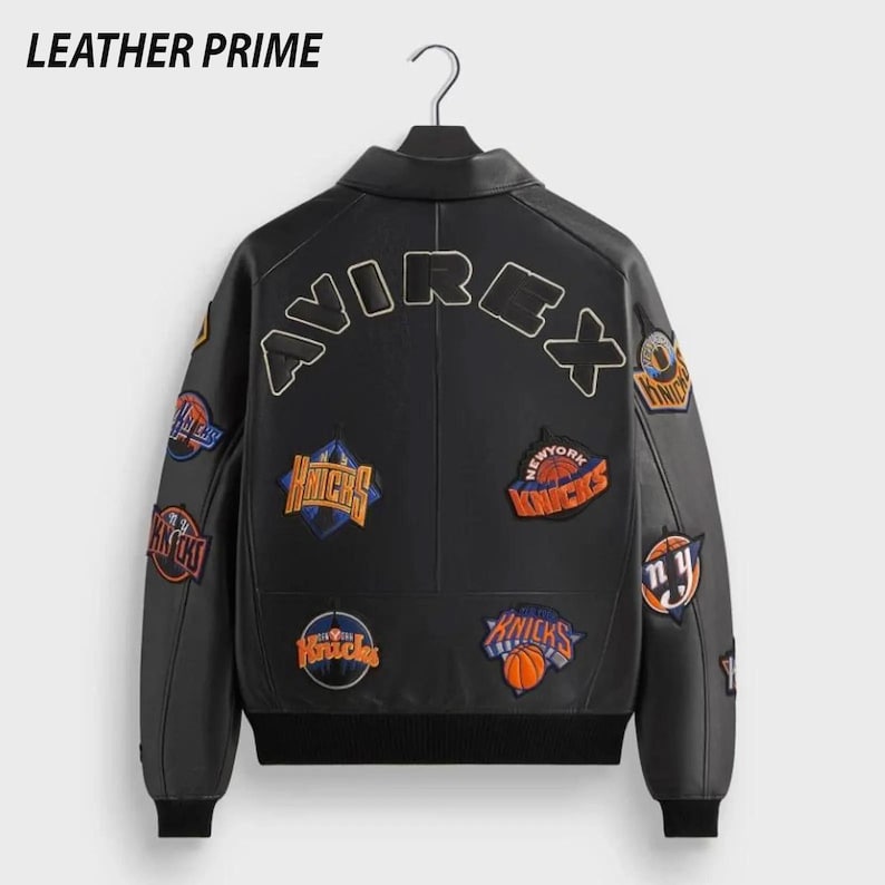 K&ouml;nnte beinhalten: Schwarze Lederjacke mit mehreren Aufn&auml;hern mit Basketball-Teamlogos. Auf der R&uuml;ckseite der Jacke steht das Wort "AVIREX" und oben der Markenname "LEATHER PRIME".