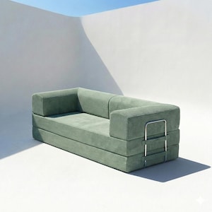 Puede incluir: Un sofá contemporáneo de pana verde salvia. El sofá tiene una forma rectangular baja con un marco de metal en el reposabrazos. La tela de pana tiene una textura acanalada. El sofá está sobre un fondo blanco. Medidas en centímetros.