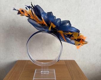 Tocado azul marino con plumas doradas en la diadema.