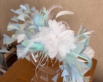 Tocado blanco con detalles de plumas azul bahía y verde menta.