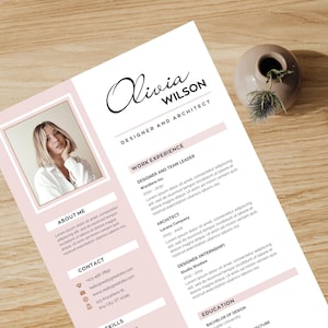 May include: A resume template with a photo of a woman, the name "Olivia Wilson", and the title "Designer and Architect". The resume has pink accents and sections for work experience, skills, and contact information. A small vase with greenery sits nearby.