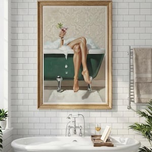 May include: A framed artwork depicts a person relaxing in a green bathtub, holding a cocktail. The bathroom features a white tub, white subway tile, and a window with plants. A tray with a glass of wine and a book sits nearby.