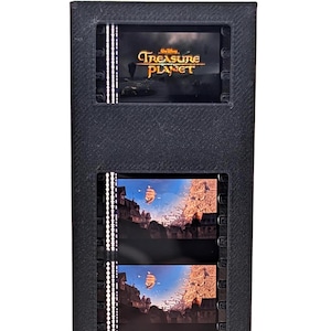 May include: A black film strip display featuring scenes from the movie "Treasure Planet." The display includes the movie title at the top and several film cells showing a ship sailing across a blue sky. The display is rectangular and stands upright.