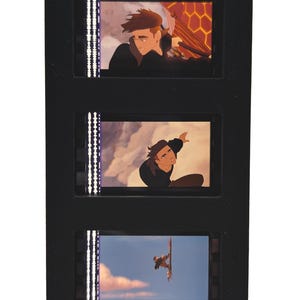 May include: A black film strip with three animated film cells. Each cell features a scene from an animated movie. The top cell shows a man with brown hair. The middle cell shows a man reaching up. The bottom cell shows a man on a board.