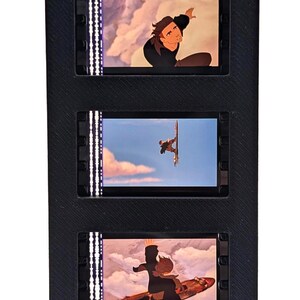 May include: A black, vertical display featuring five animated film cells. Each cell shows a scene with a character in various action poses. The scenes are lit with a white light on the left side of each cell.